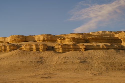 Free Scenic view of sunlit sandstone cliffs in Faiyum, Egypt during sunset. Stock Photo