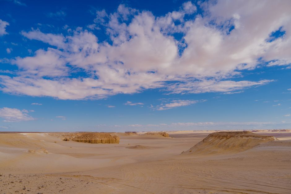 Vast desert landscape in Ahmadi Governorate, Kuwait, with sand dunes and clear skies