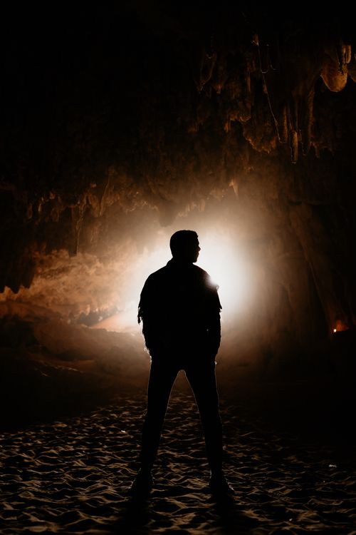 Free Silhouette of man standing in illuminated cave at Siwa Oasis, Egypt. Mystery and adventure. Stock Photo