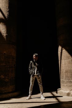 A striking portrait of a man in dramatic light and shadows at an ancient temple in Aswan, Egypt.