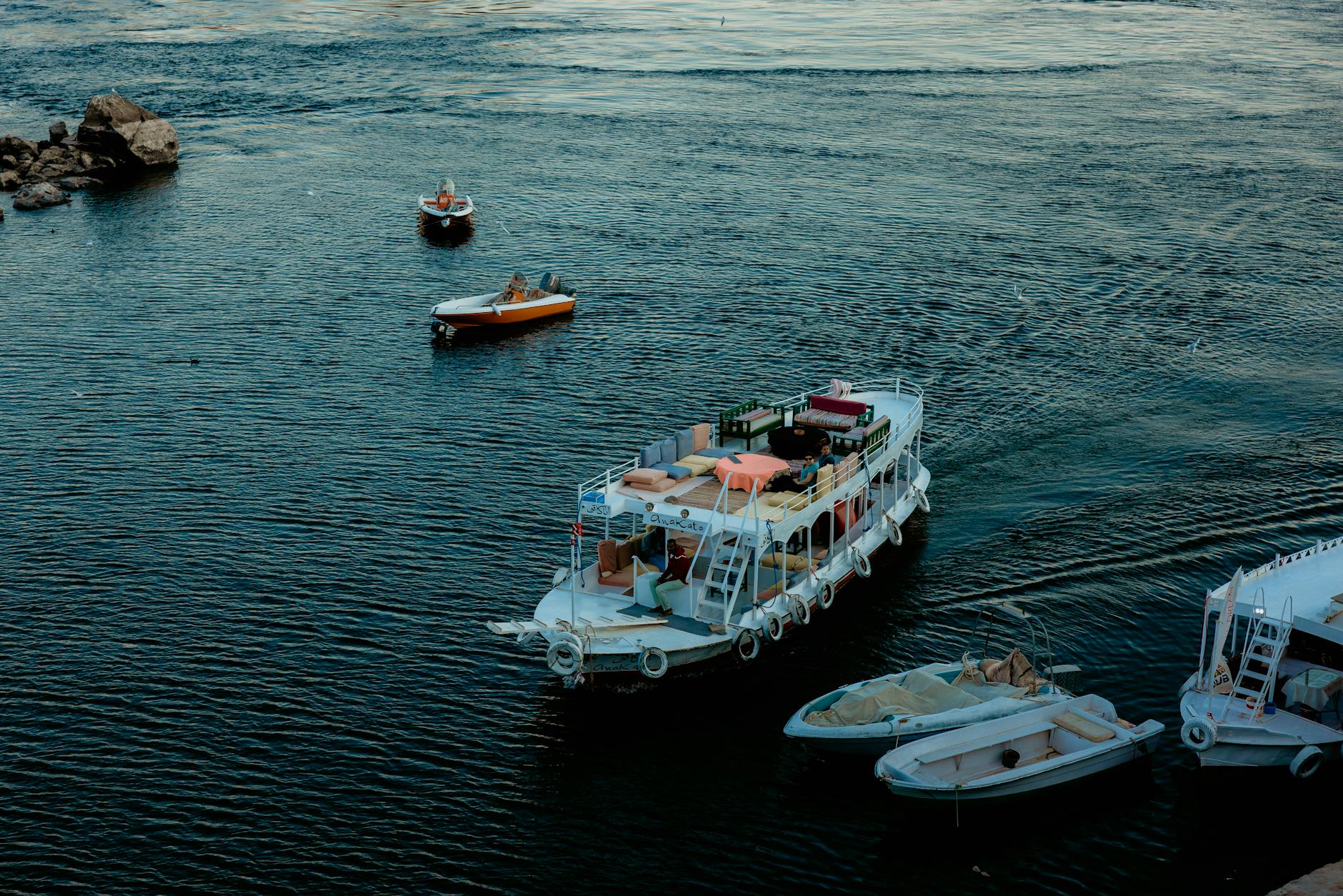 Scenic view of boats on the Nile River in Aswan, Egypt, showcasing vibrant travel and transportation.