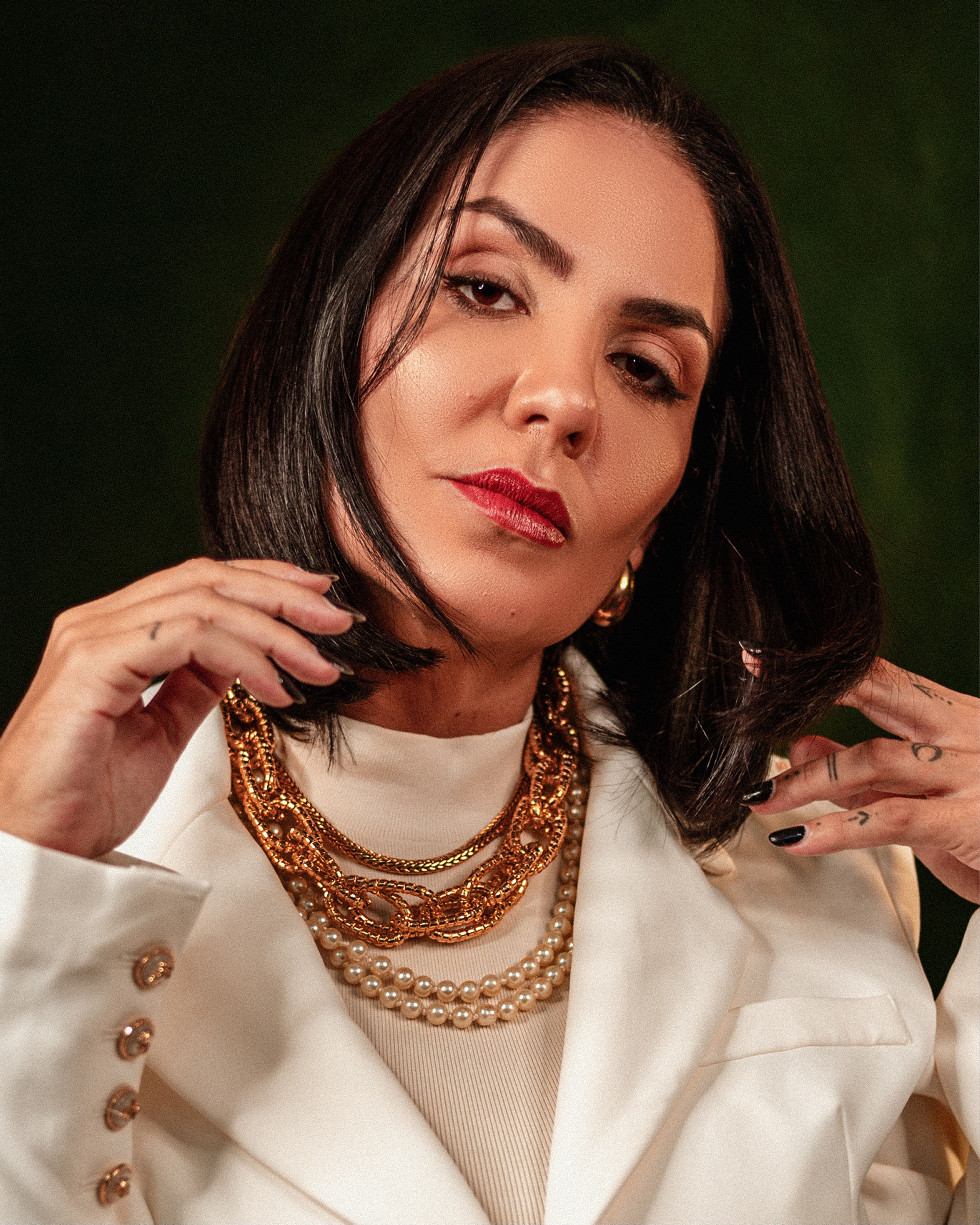 Sophisticated portrait of a woman adorned in luxurious gold and pearl jewelry, showcasing elegance and style.