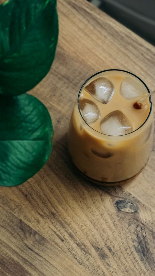 Free Top view of a refreshing iced coffee with milk on a rustic wooden table. Stock Photo