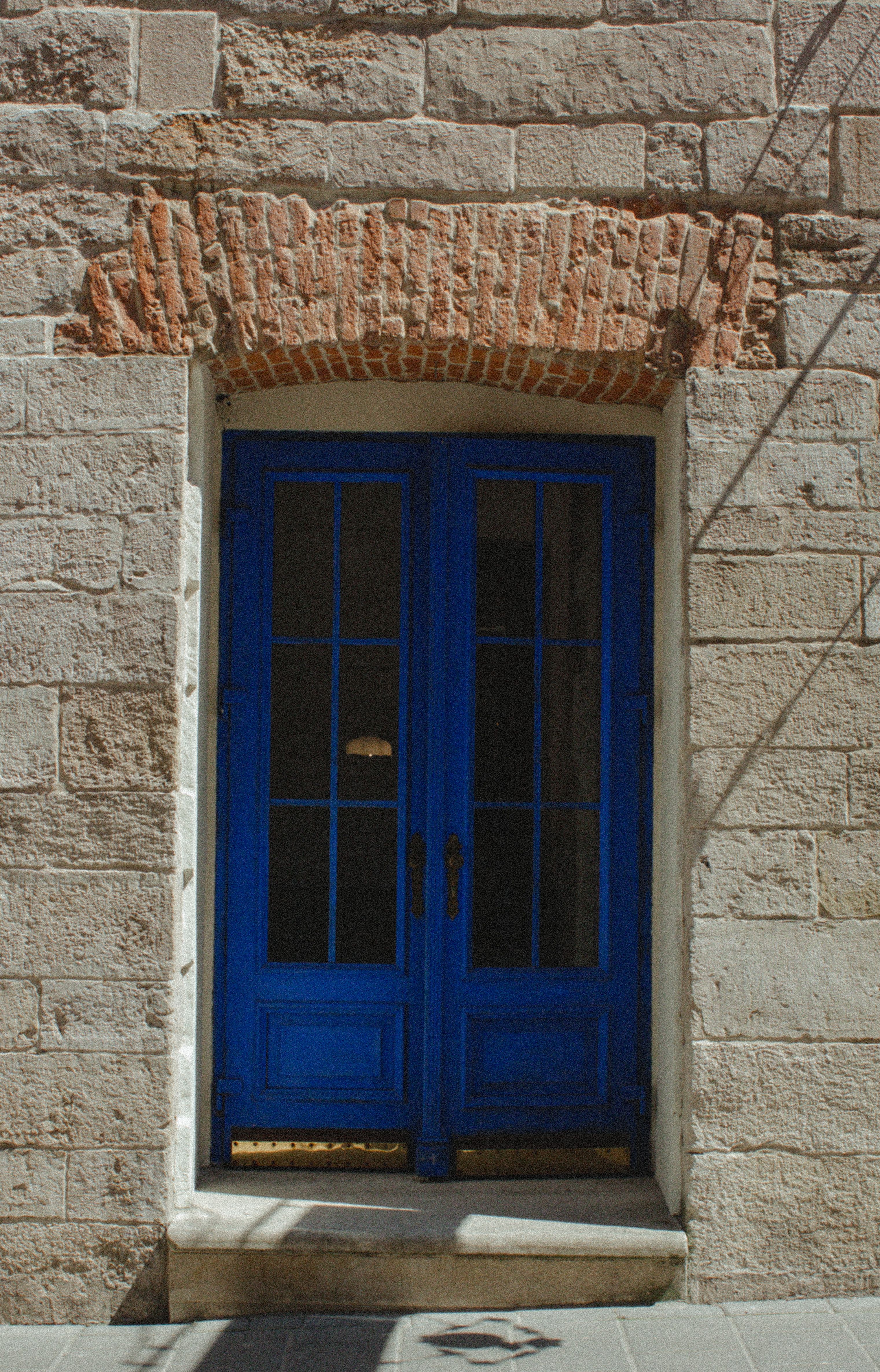 Vibrant blue door set in a rustic stone facade showcasing architectural charm.