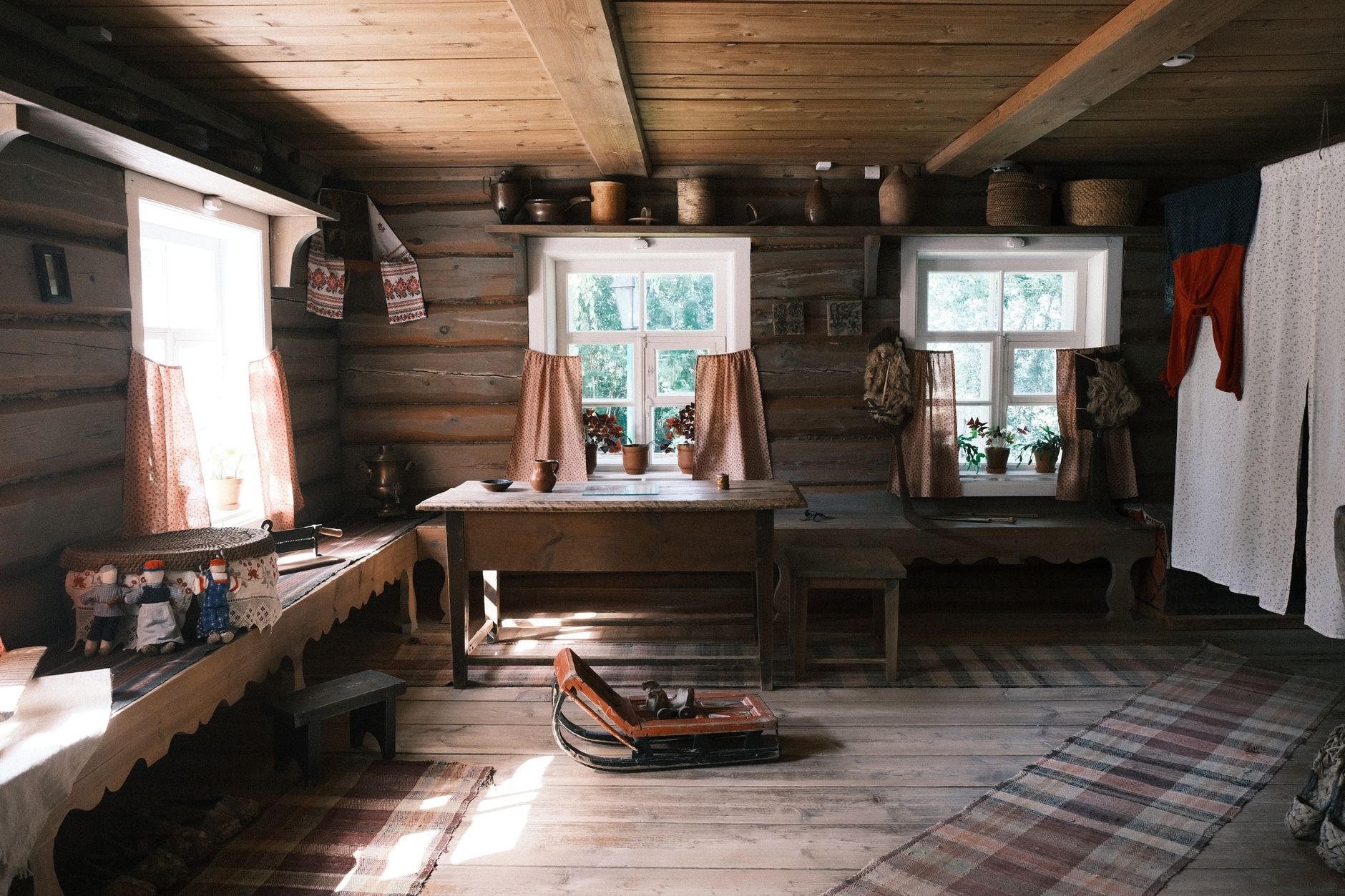 Warm wooden interior cabin with fabrics, furniture, and natural light.