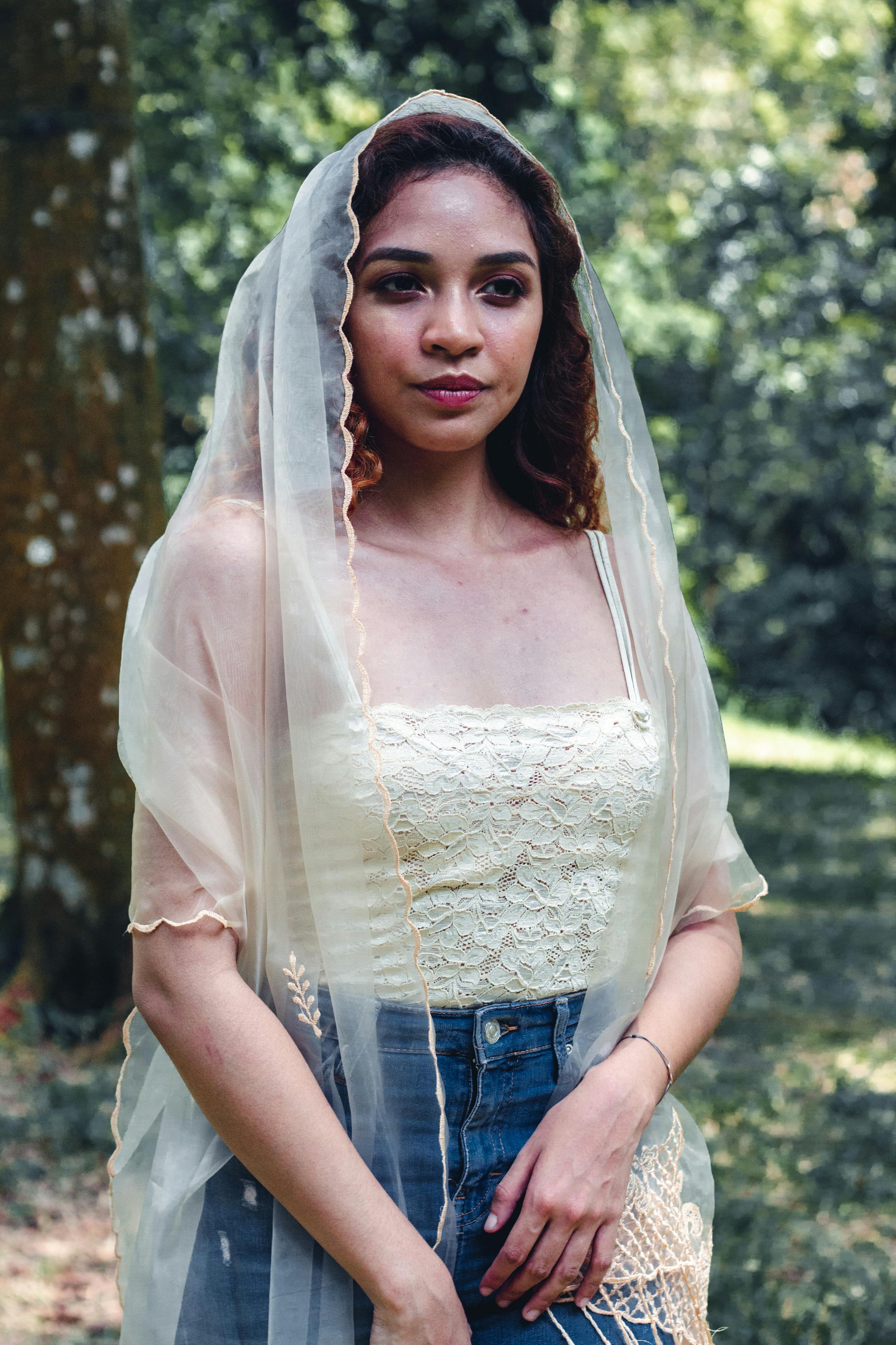 一位戴着面纱的女子在户外公园的宁静肖像，传递出优雅的气质