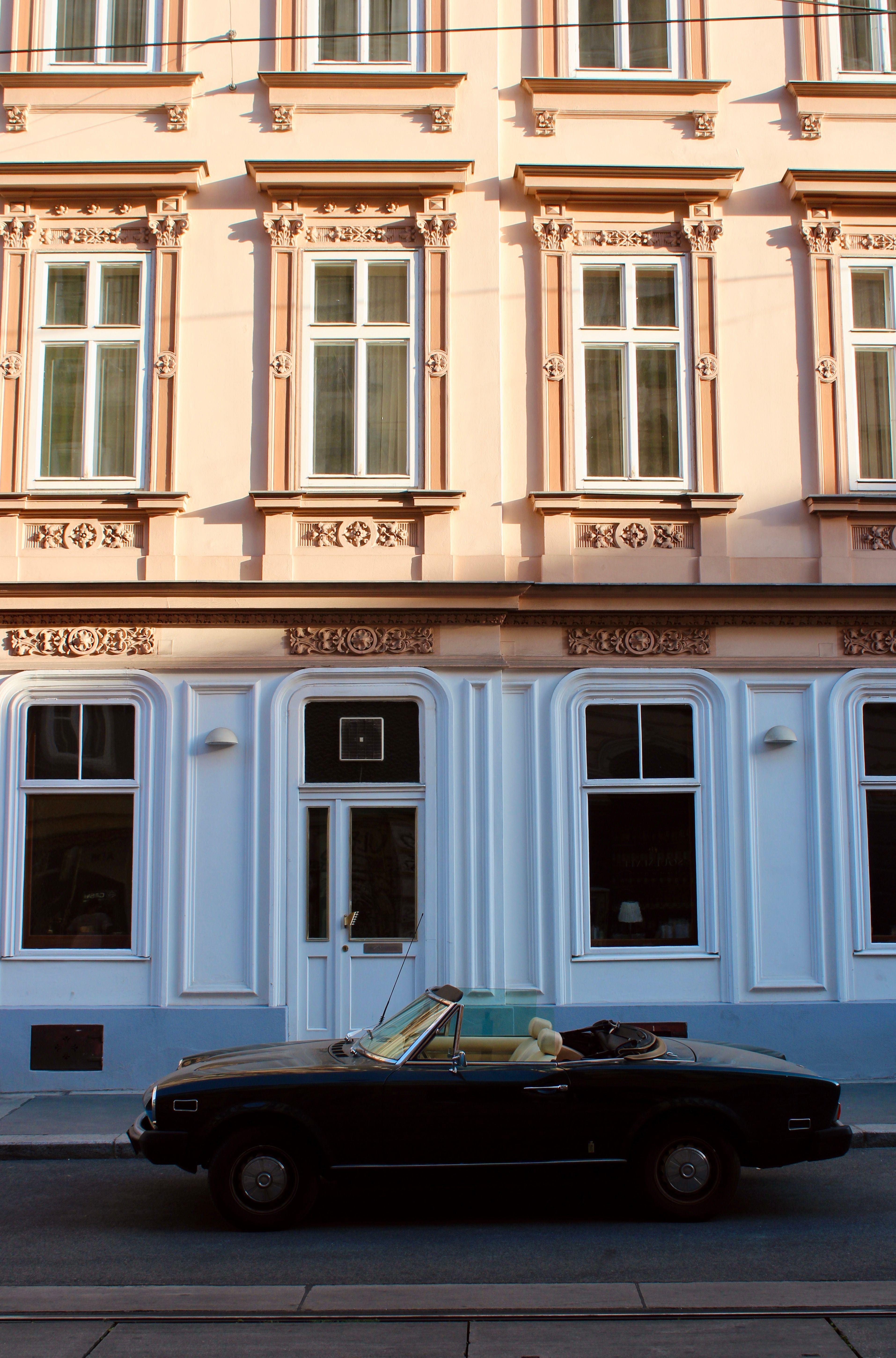 A black car parked in front of a building · Free Stock Photo