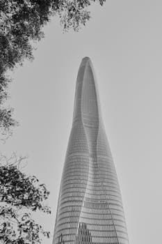 A tall, modern skyscraper captured from below, set against a clear sky.