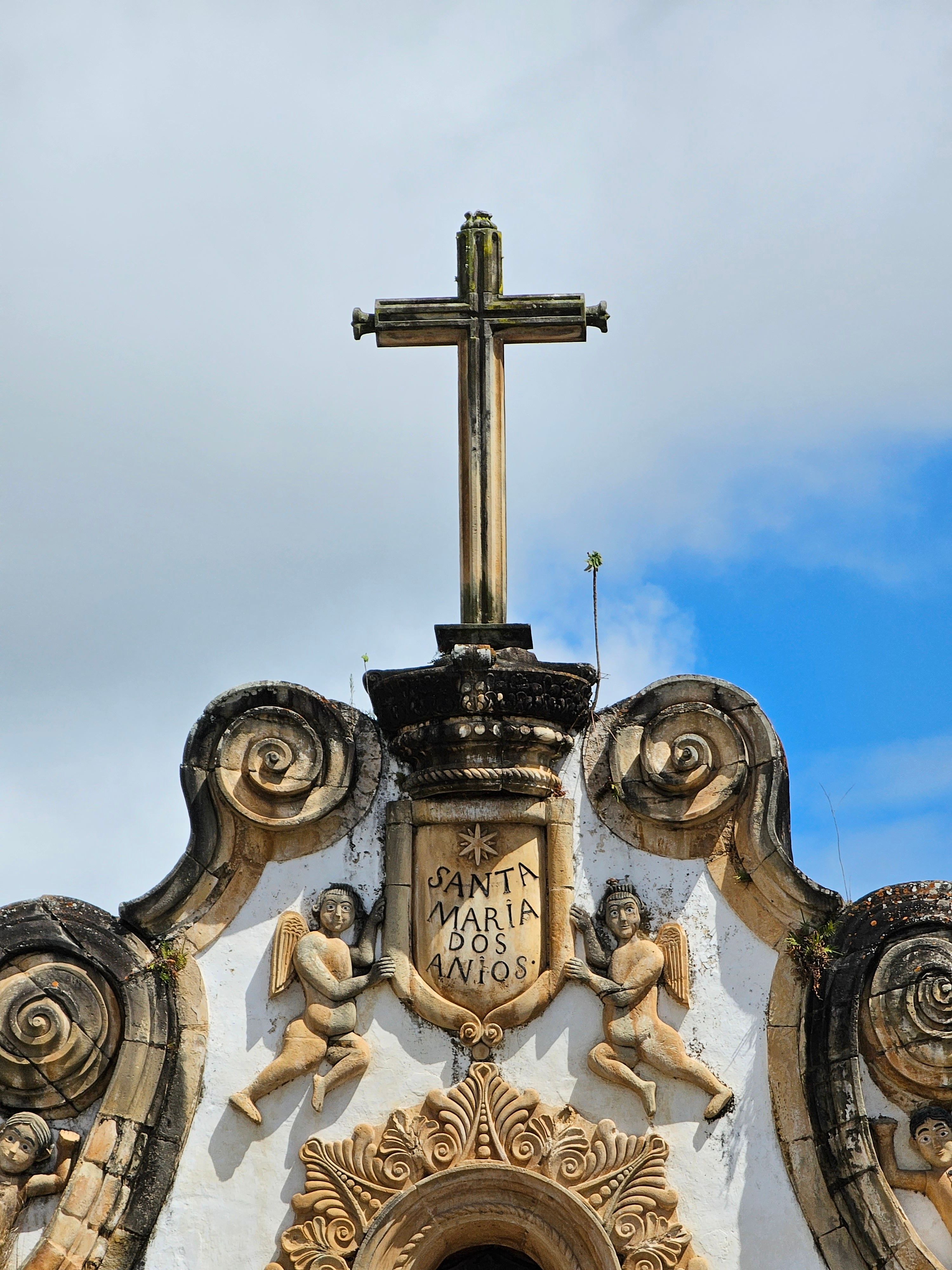 A cross on top of a building with a clock · Free Stock Photo