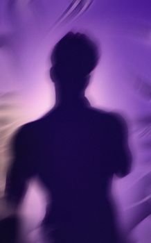 An artistic silhouette of a person against a blurred purple background, creating a surreal effect.