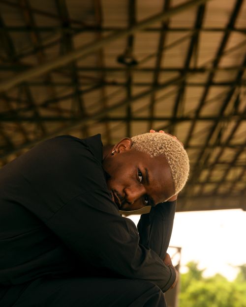 Free Striking portrait of a man sitting pensively, showcasing modern style and attitude. Stock Photo