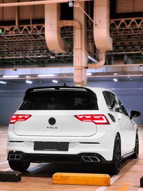 Free Rear view of a white Polo car in a brightly lit indoor parking area. Stock Photo