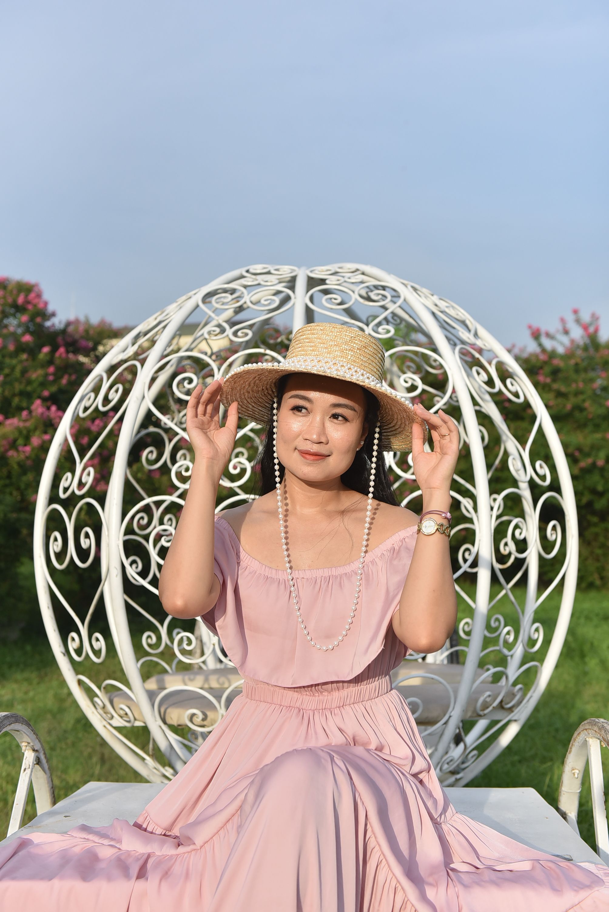 A woman in a pink dress sitting on a white chair · Free Stock Photo