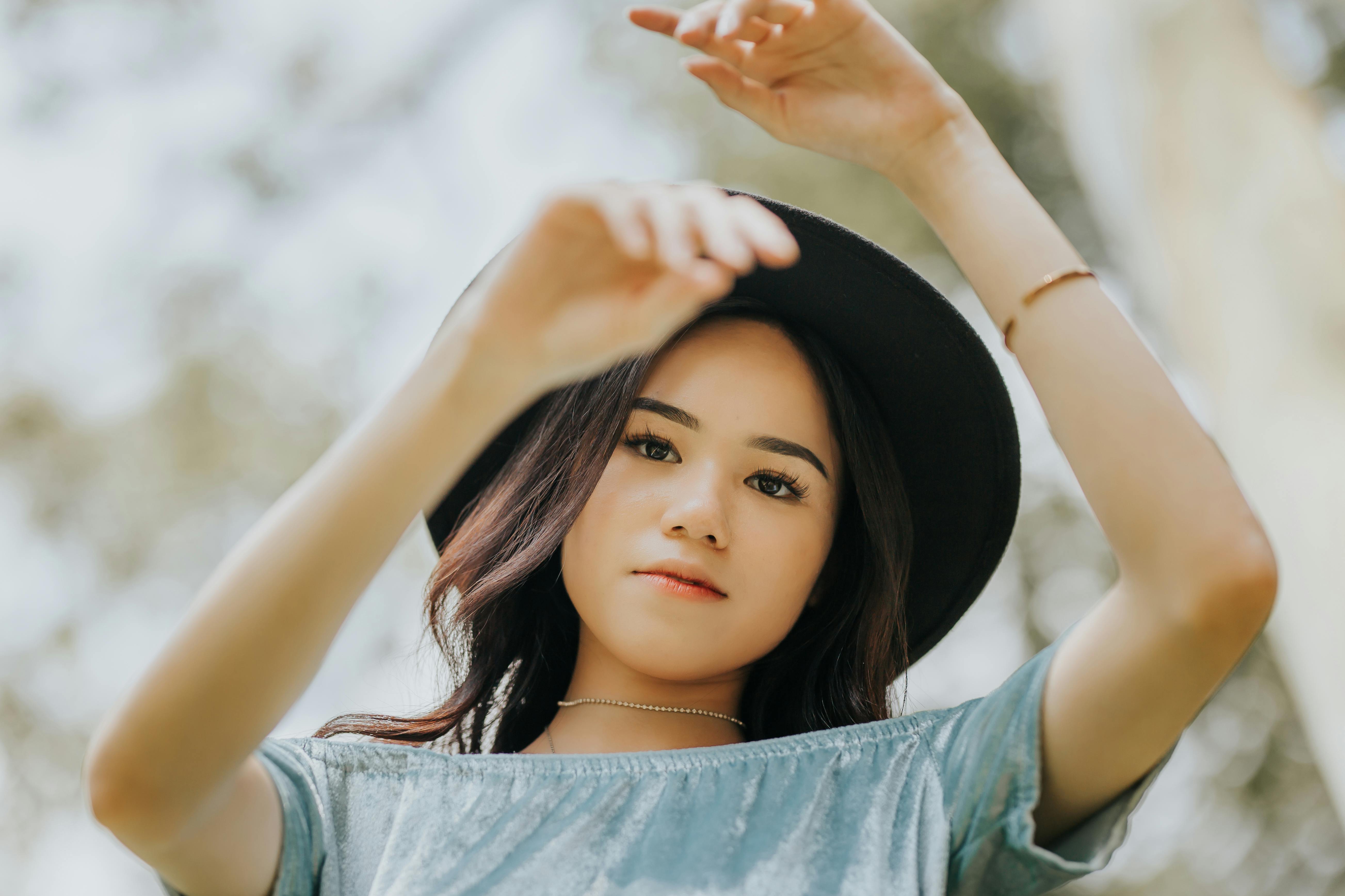 一位戴着遮阳帽的时尚女士在户外自信地摆着姿势，展示自己的风格