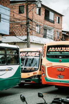 Exterior of old town with aged brick buildings and bright busses on cloudy day