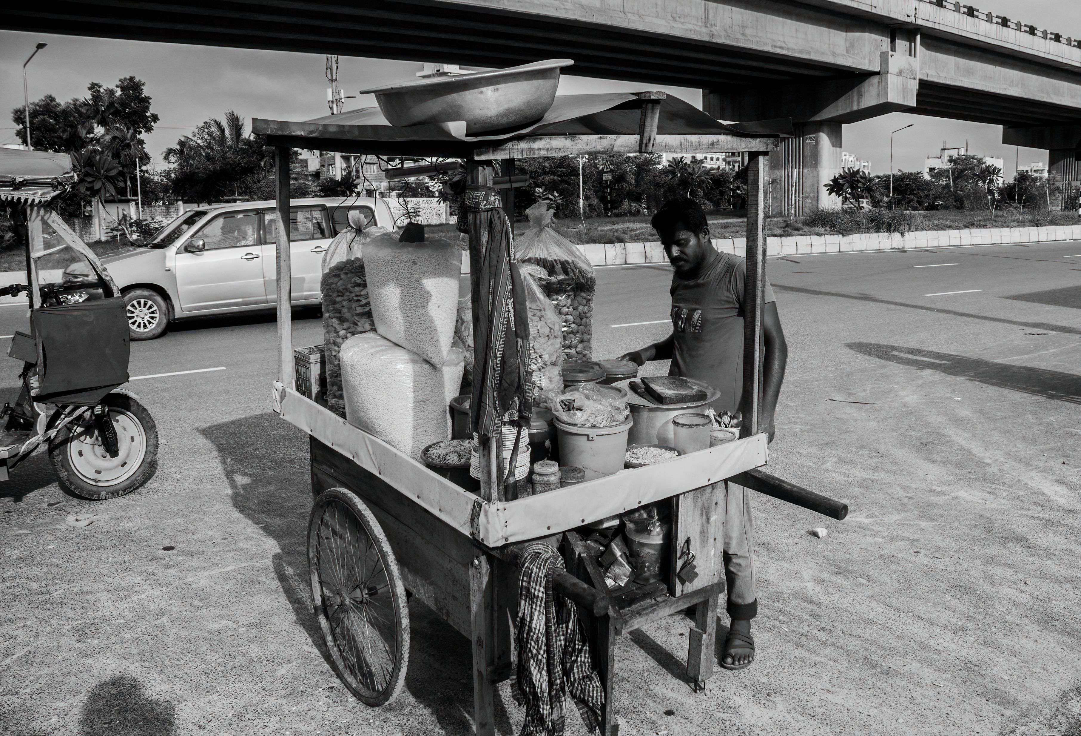 A black and white photo of a man selling food · Free Stock Photo