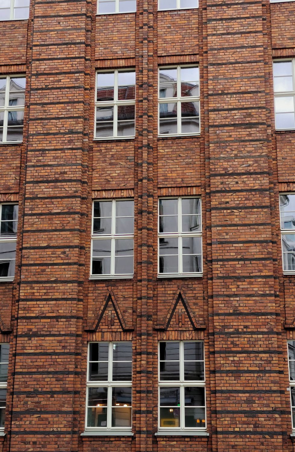 A tall brick building with windows and a clock · Free Stock Photo