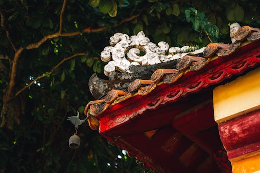 Intricate roof detail of a traditional temple in Huế, showcasing vibrant colors and Asian architectural elements.
