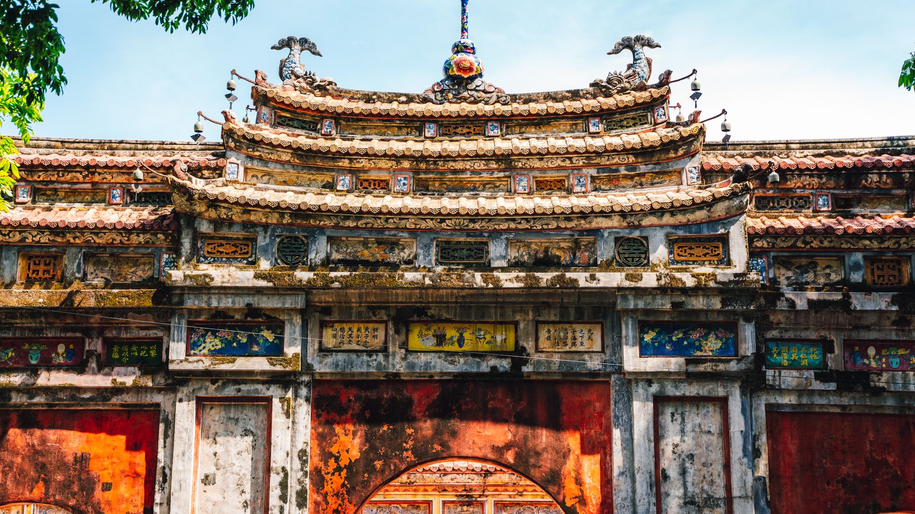Explora la intrincada arquitectura de una puerta histórica en la Ciudad Imperial de Hue, Vietnam.