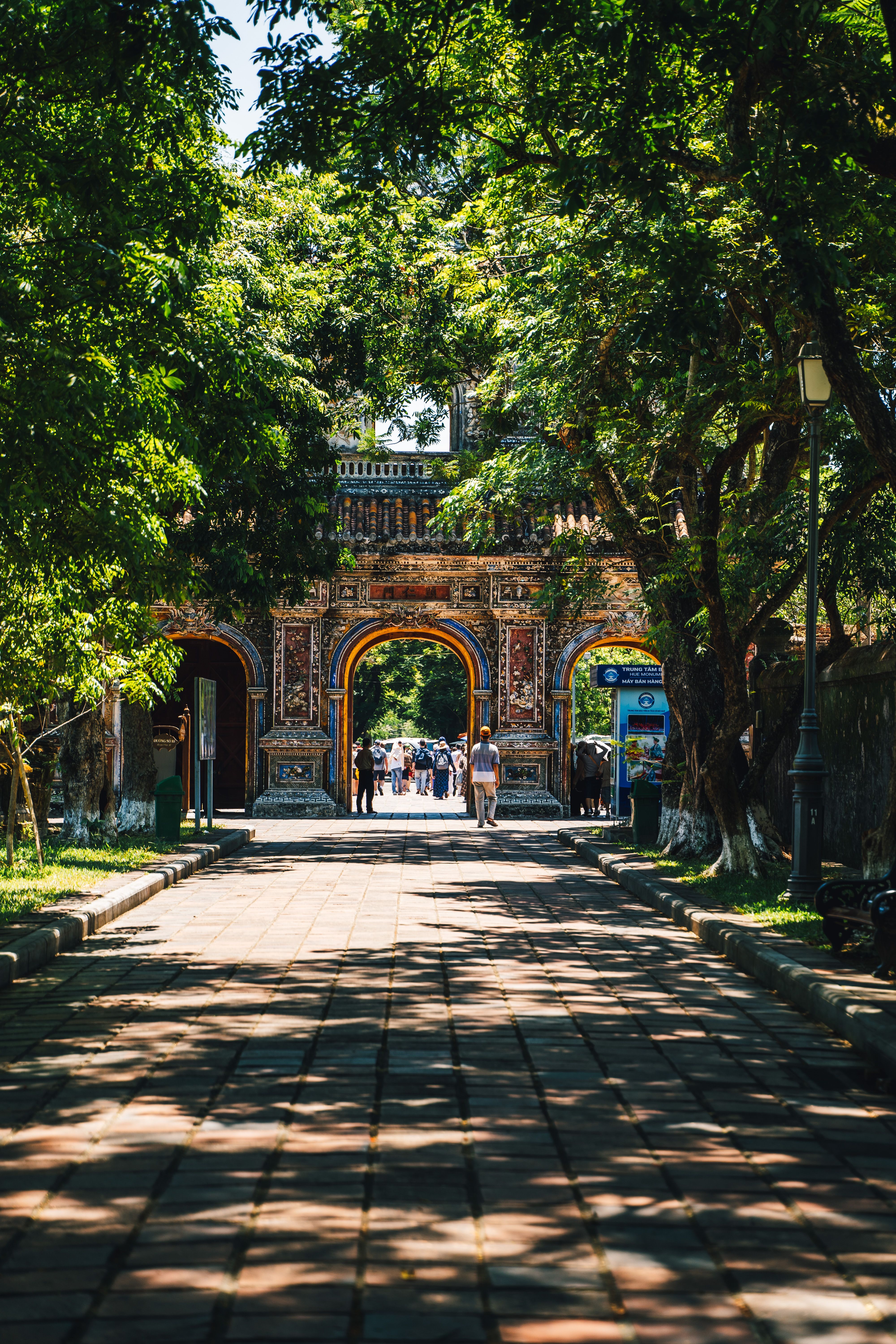 Scenic view of a historic gateway in Huế, Vietnam, surrounded by lush trees.