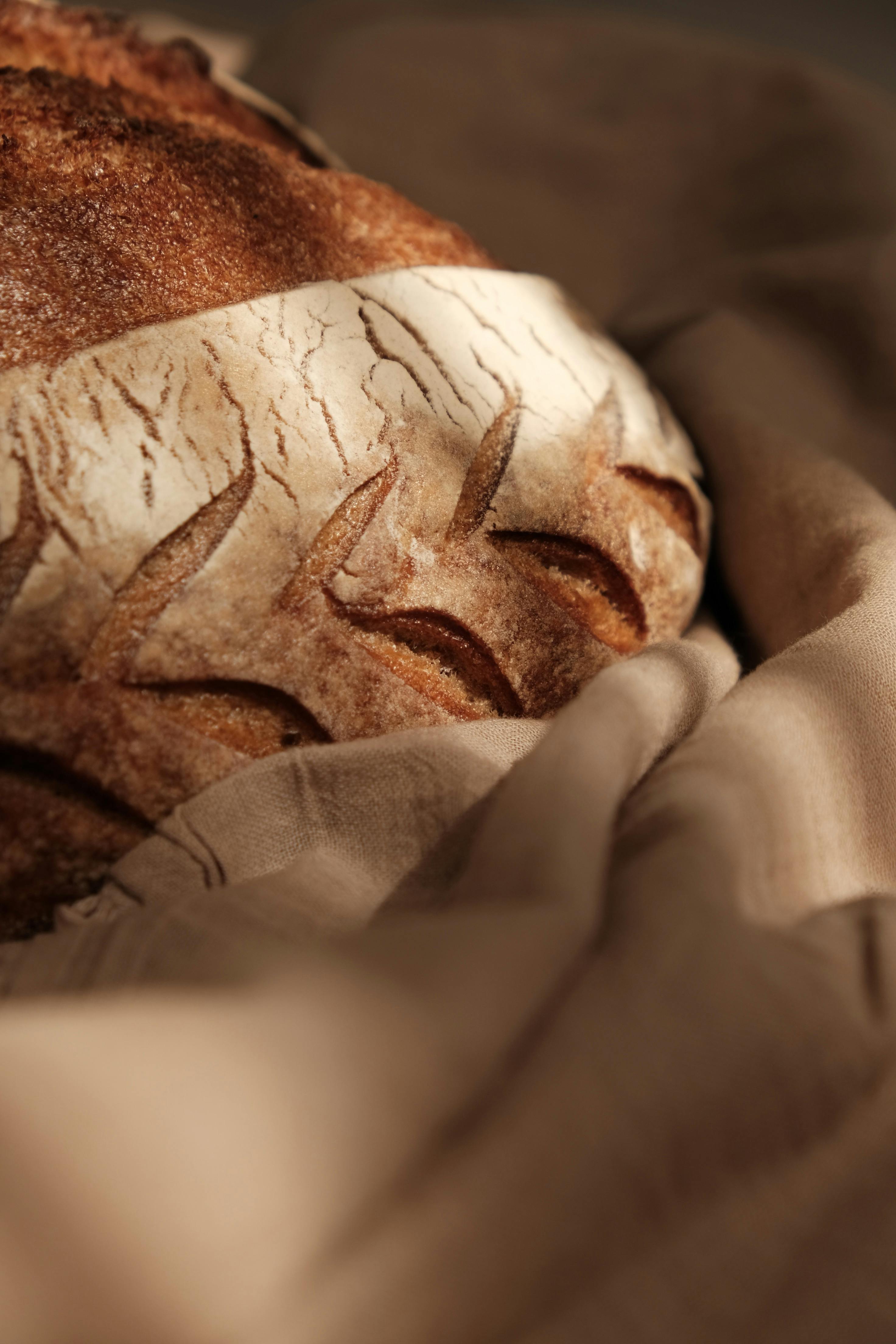 a loaf of bread on a cloth with a brown background