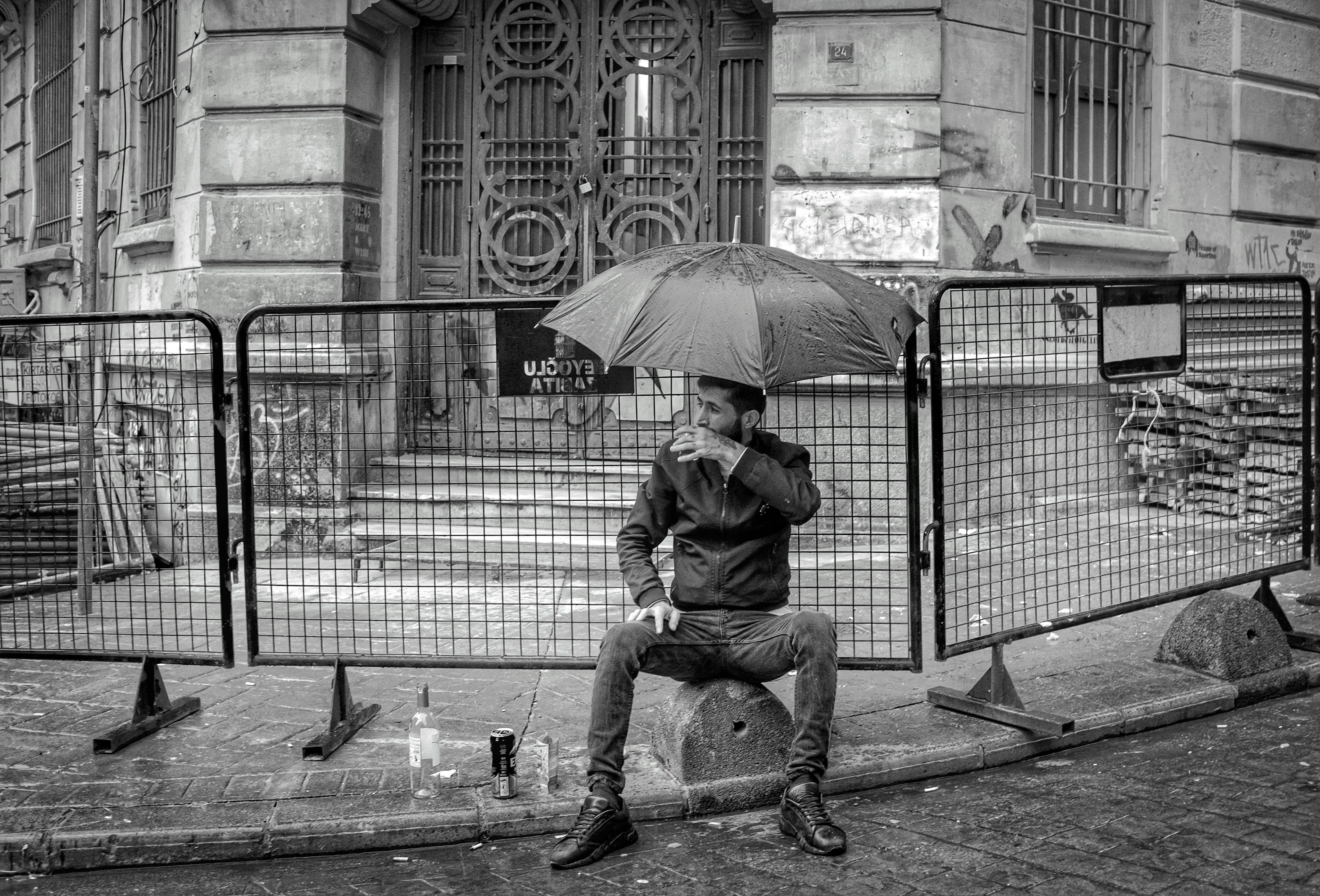 a man sitting on the ground with an umbrella