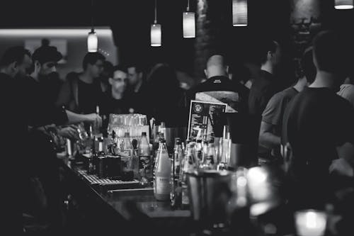 Photographie En Niveaux De Gris De Bouteilles Sur Le Dessus De La Table