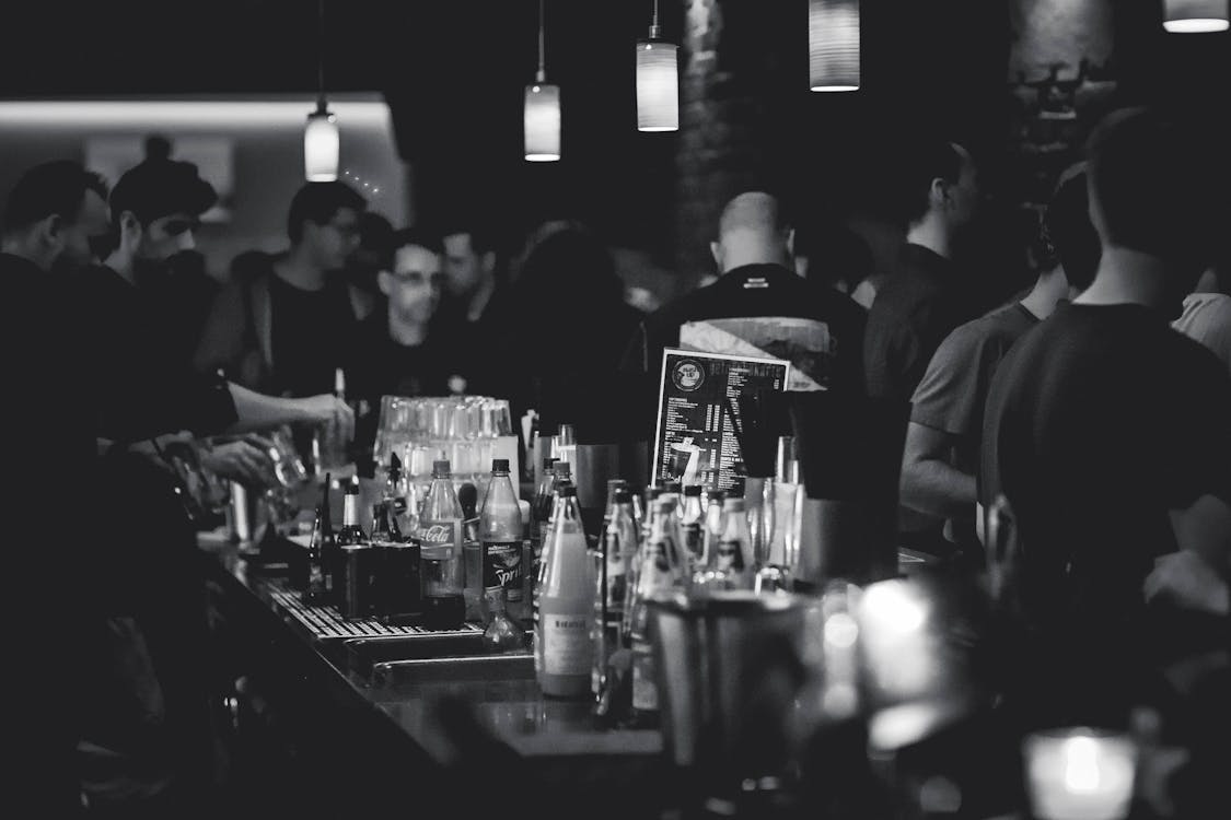 Grayscale Photography of Bottles on Top of Table