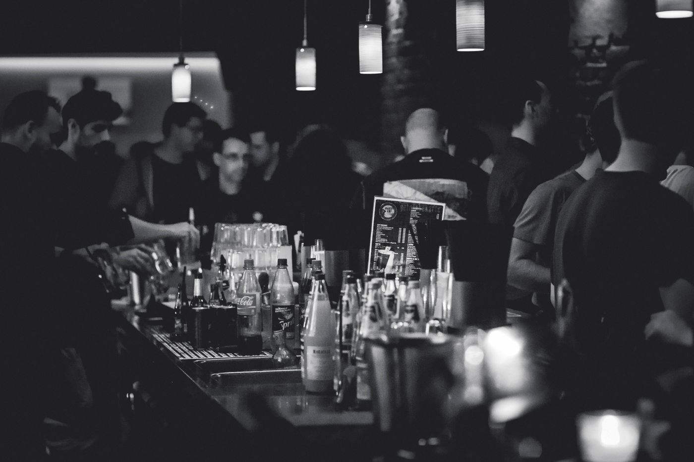 Bartender pouring drinks behind a busy bar