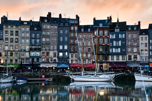 Free Picturesque view of Honfleur harbor in Normandy with historic buildings and sailboats at sunset. Stock Photo