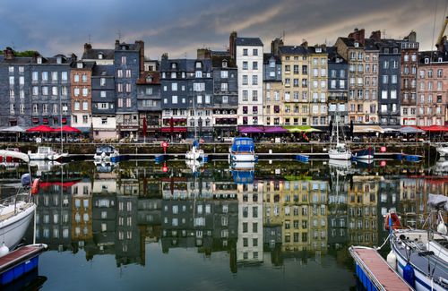 Free Vibrant reflection of charming buildings in Honfleur's historic harbor, Normandy. Stock Photo