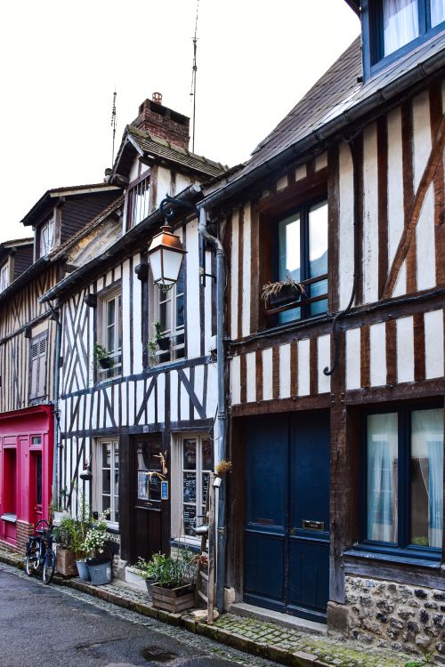 Free Traditional half-timbered houses line a quaint street in Honfleur, Normandy, France. Stock Photo