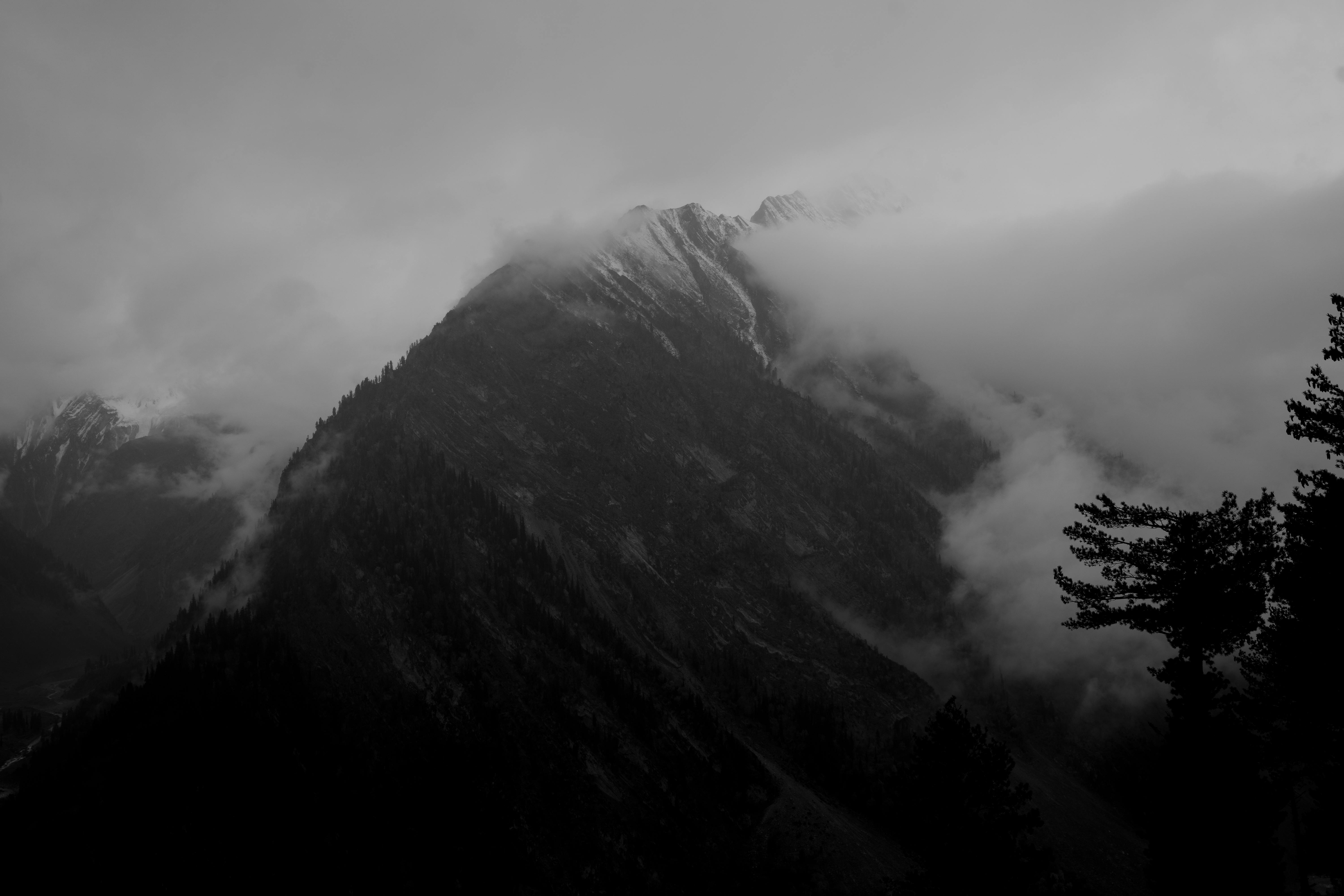 A captivating view of mist-covered mountains in Kashmir, India, creating a dramatic and moody atmosphere.