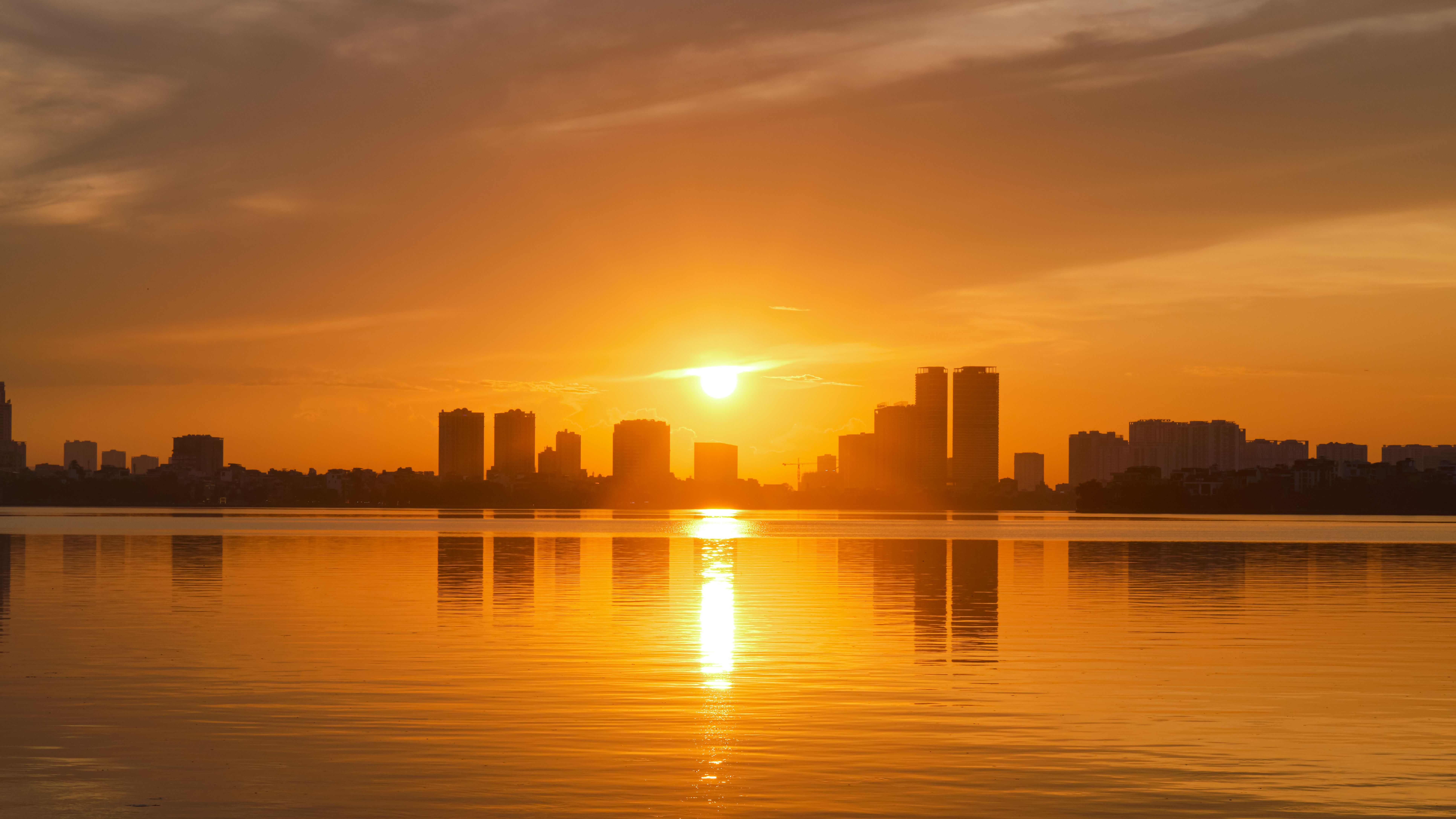Sunset over the city skyline with water · Free Stock Photo