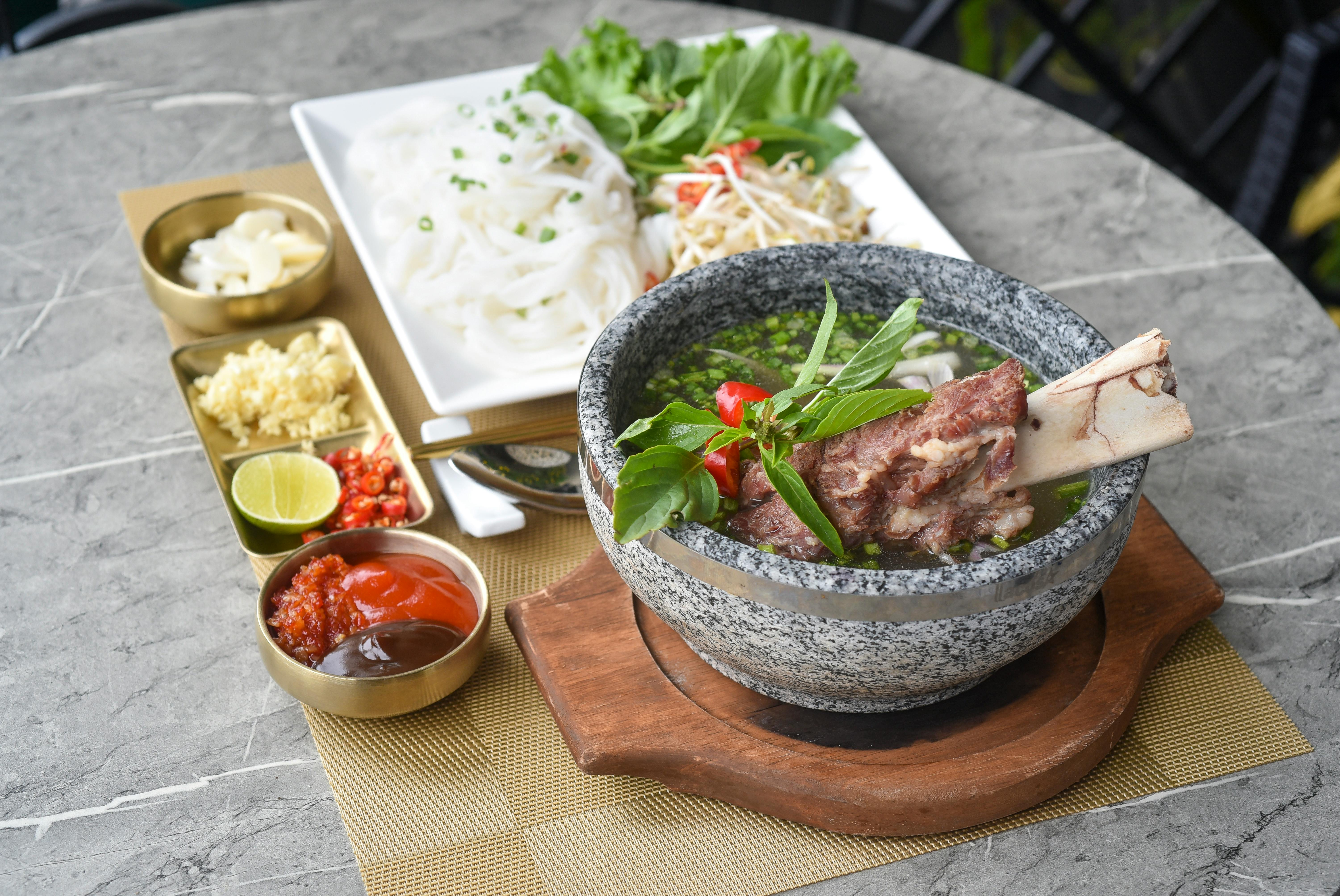 A bowl of soup with meat and vegetables on a table · Free Stock Photo