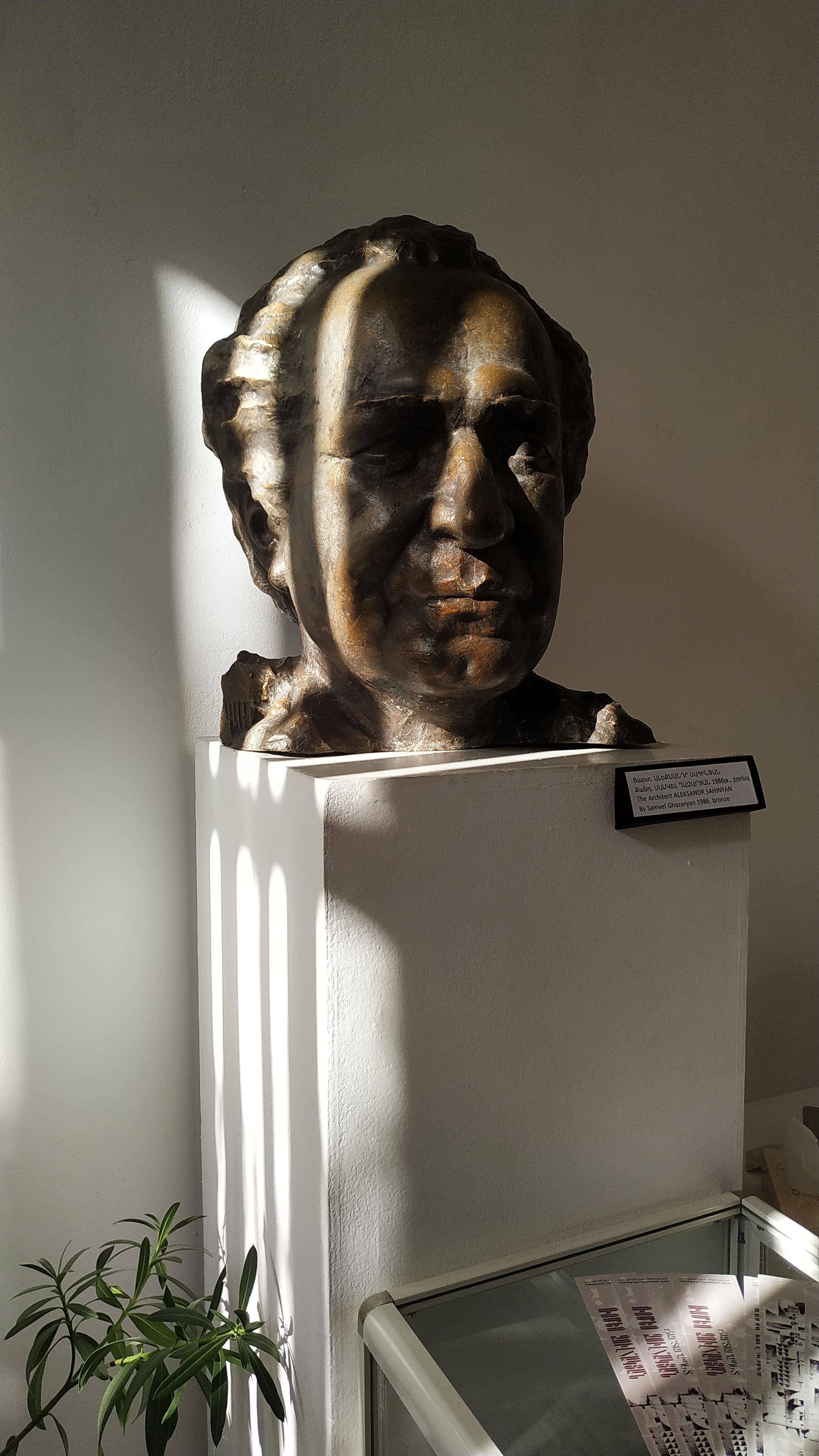 Bronze sculpture bust on display in a Yerevan museum, highlighted by sunlight.