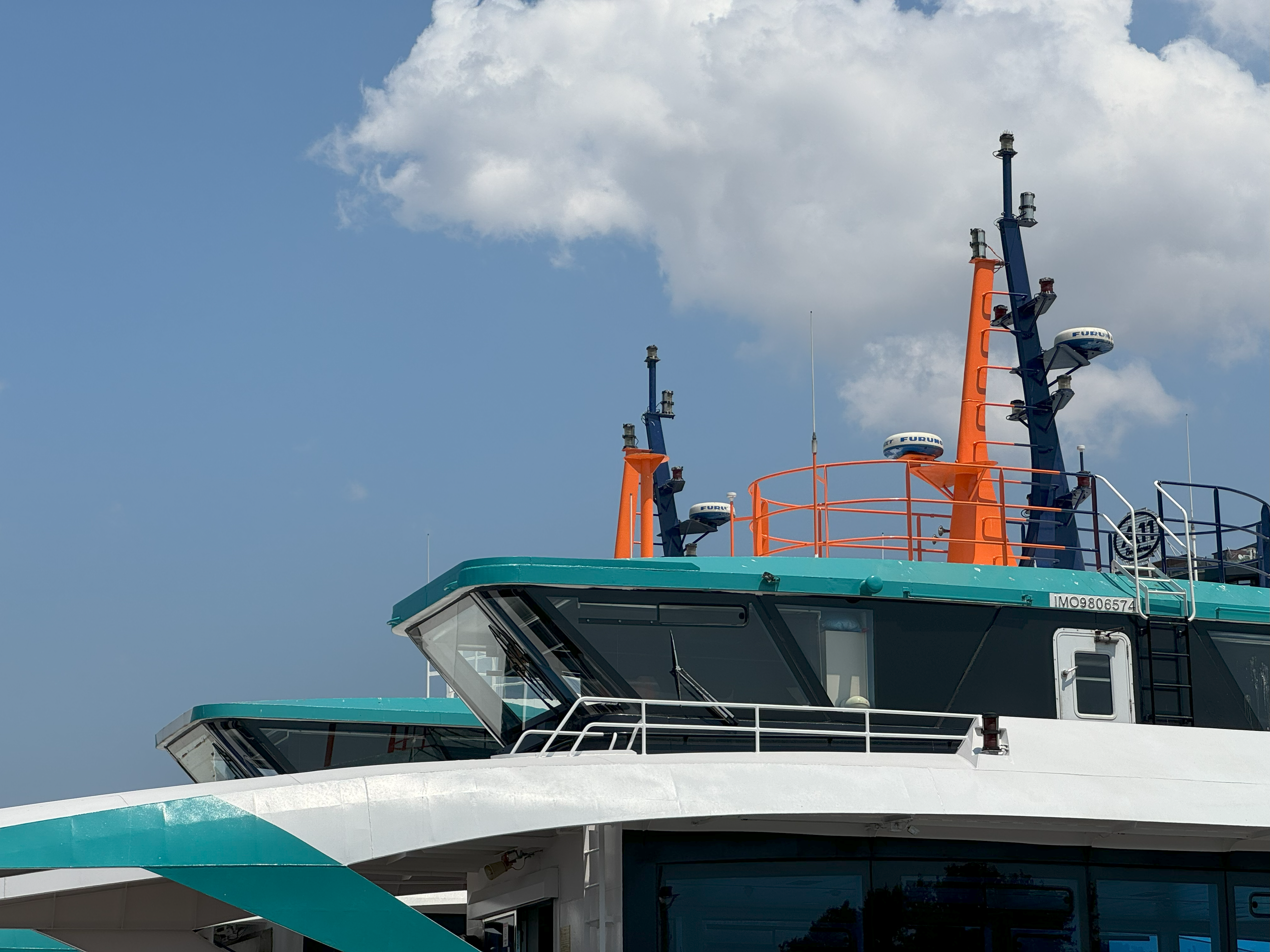 Close-up view of a modern ferry ship's upper deck against a clear sky, perfect for travel themes.
