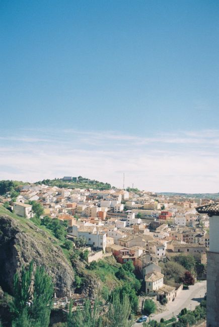 Scenic view of Cuenca's architecture and vibrant landscape under a clear blue sky.