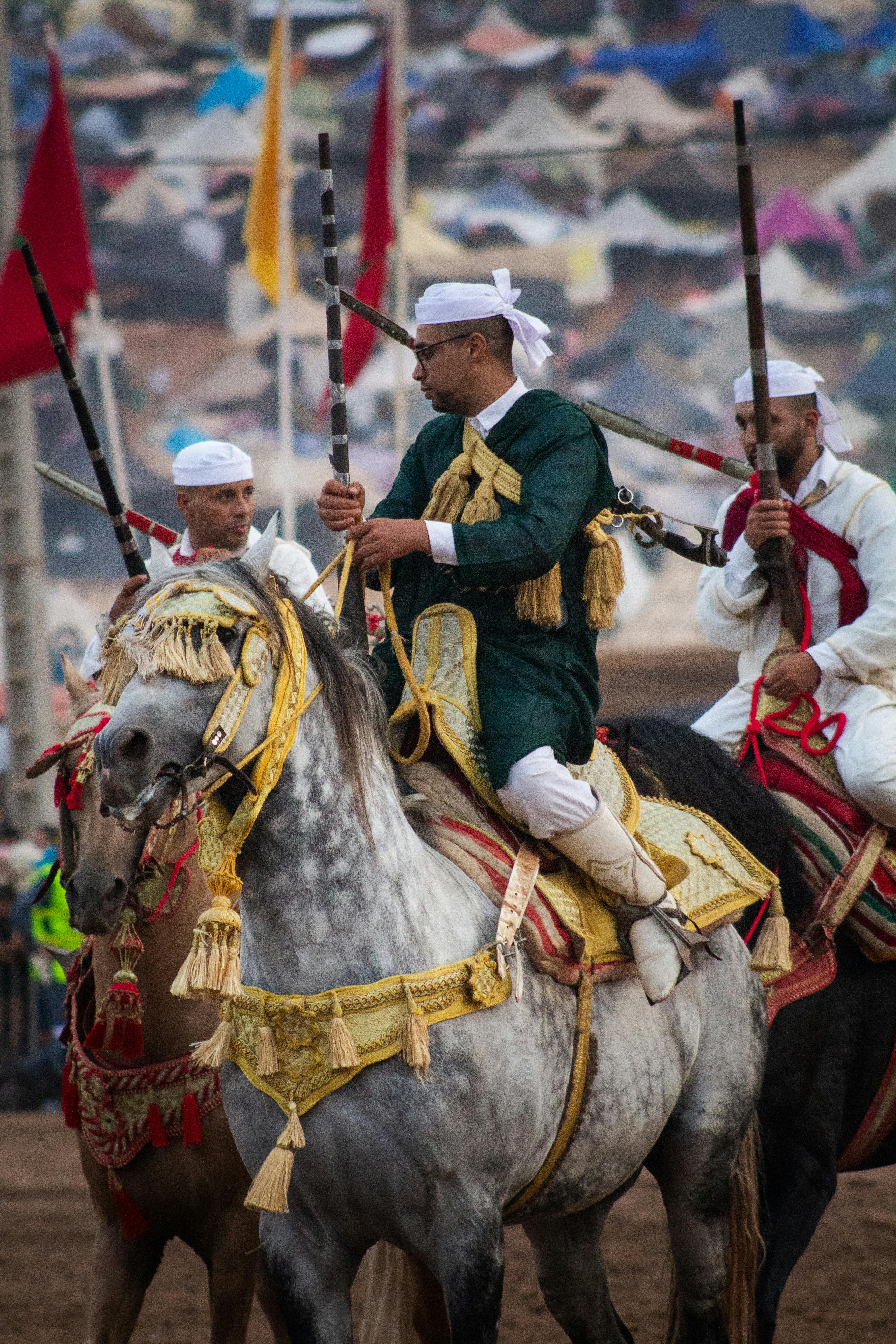 Traditional Moroccan horsemen in Tbourida festival wearing ceremonial attire.