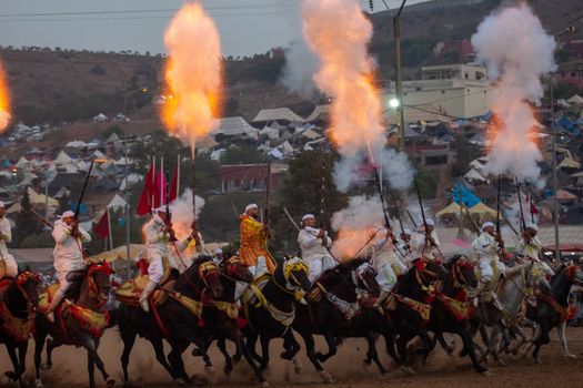 A group of Moroccan horsemen perform a Tbourida display with smoke and fire in Sidi Moussa El Mejdoub.