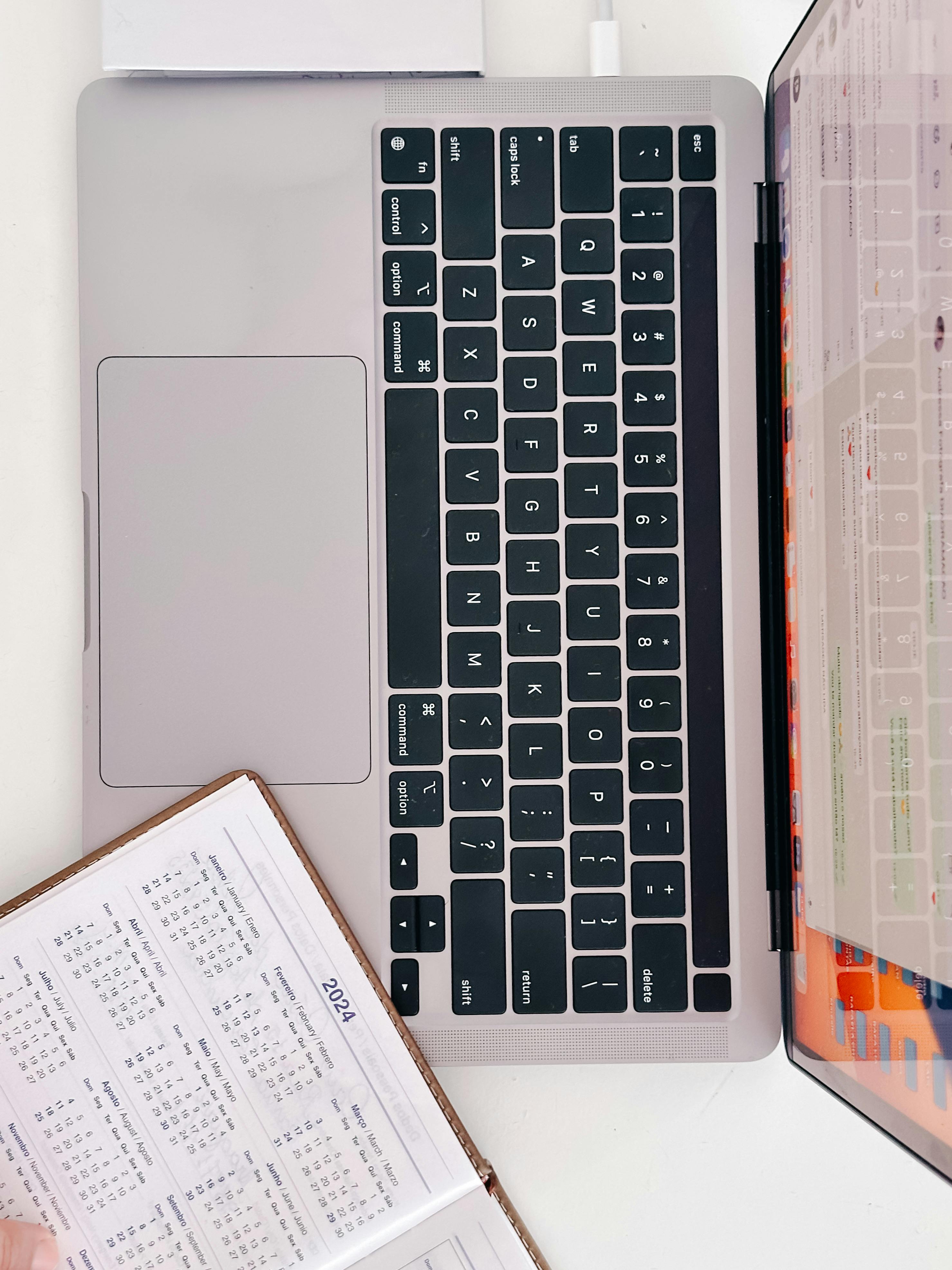 Overhead view of a laptop with an open calendar and document, perfect for office productivity themes.