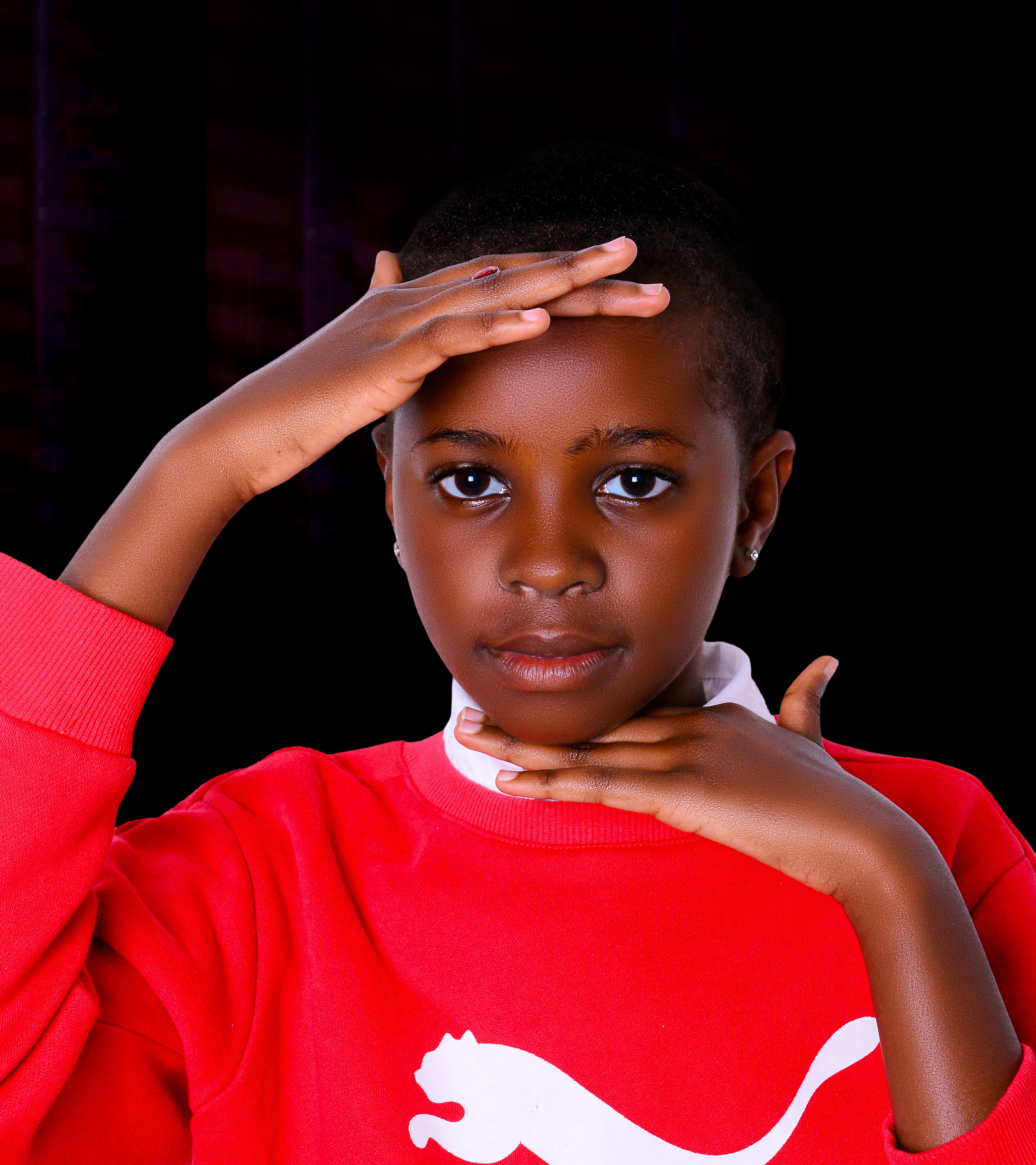A young boy in a red sweatshirt is posing for a photo · Free Stock Photo