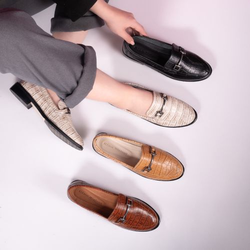Free Stylish women's moccasins in diverse colors, featuring croc-textured leather. Perfect for fashion-forward looks. Stock Photo