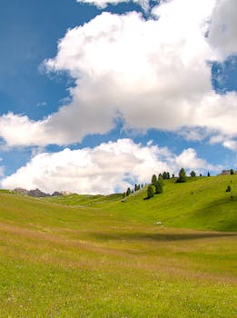 Lush green hills and cloudy sky in Santa Cristina Valgardena, Italy.