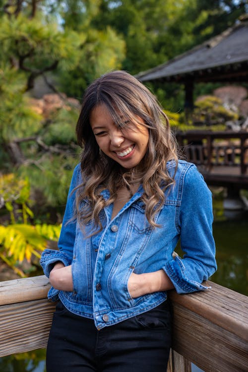 Photo of Woman Leaning on Wooden Railing