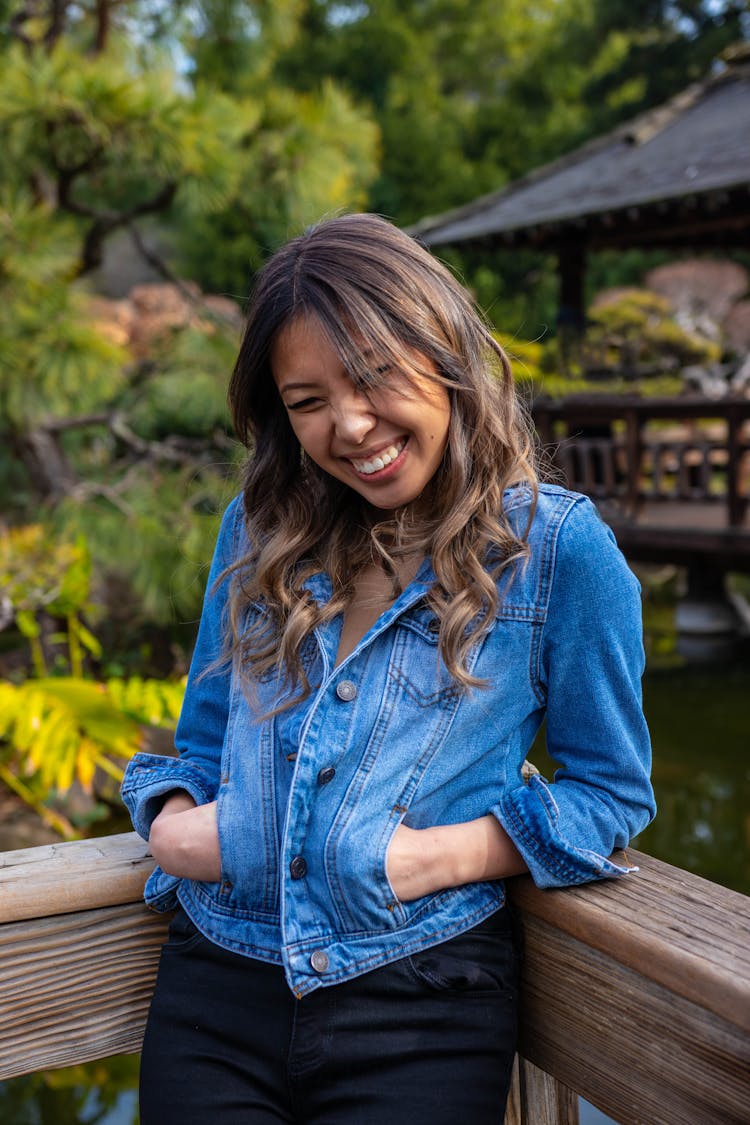 Photo Of Woman Leaning On Wooden Railing