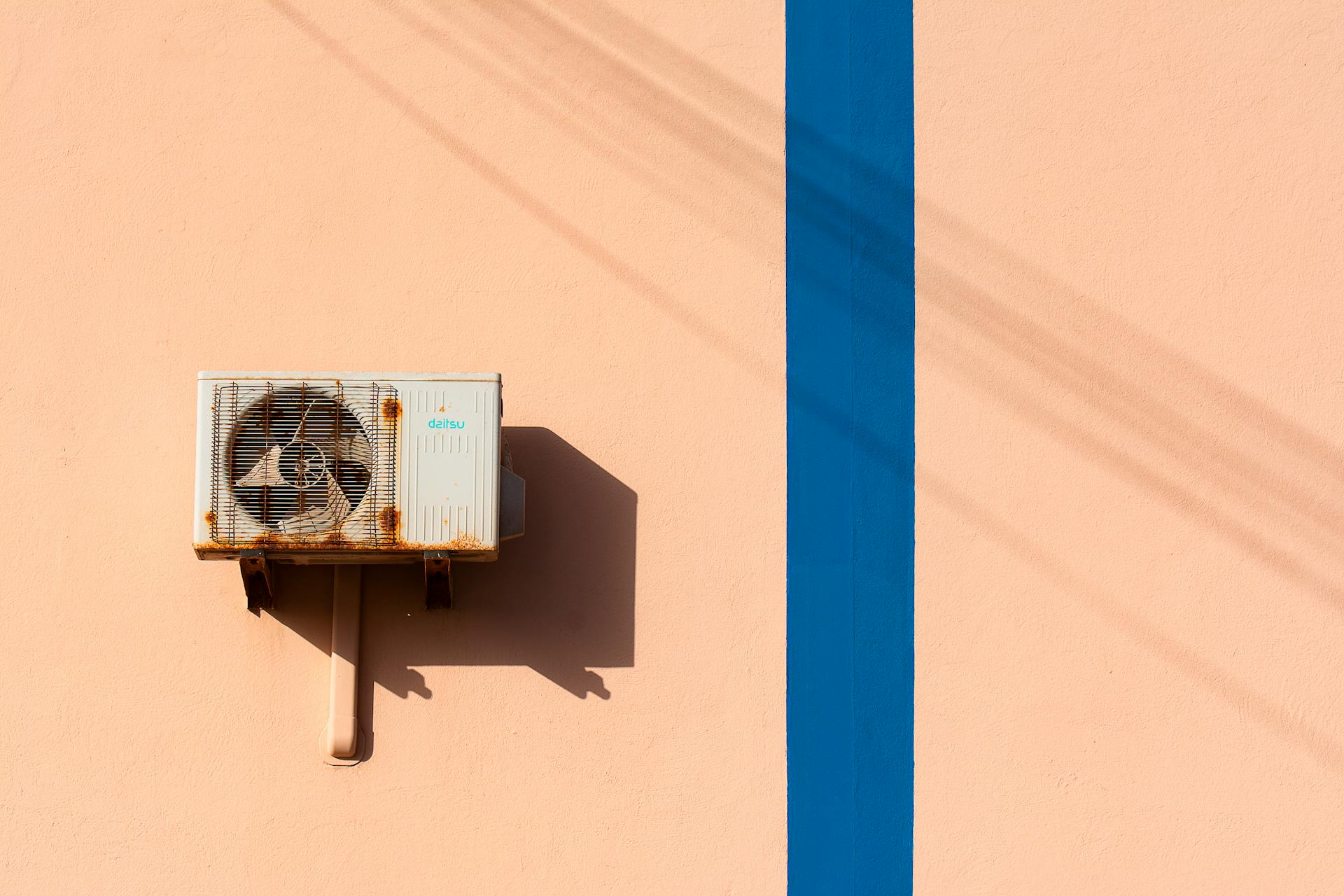 An air conditioner on a wall with blue lines