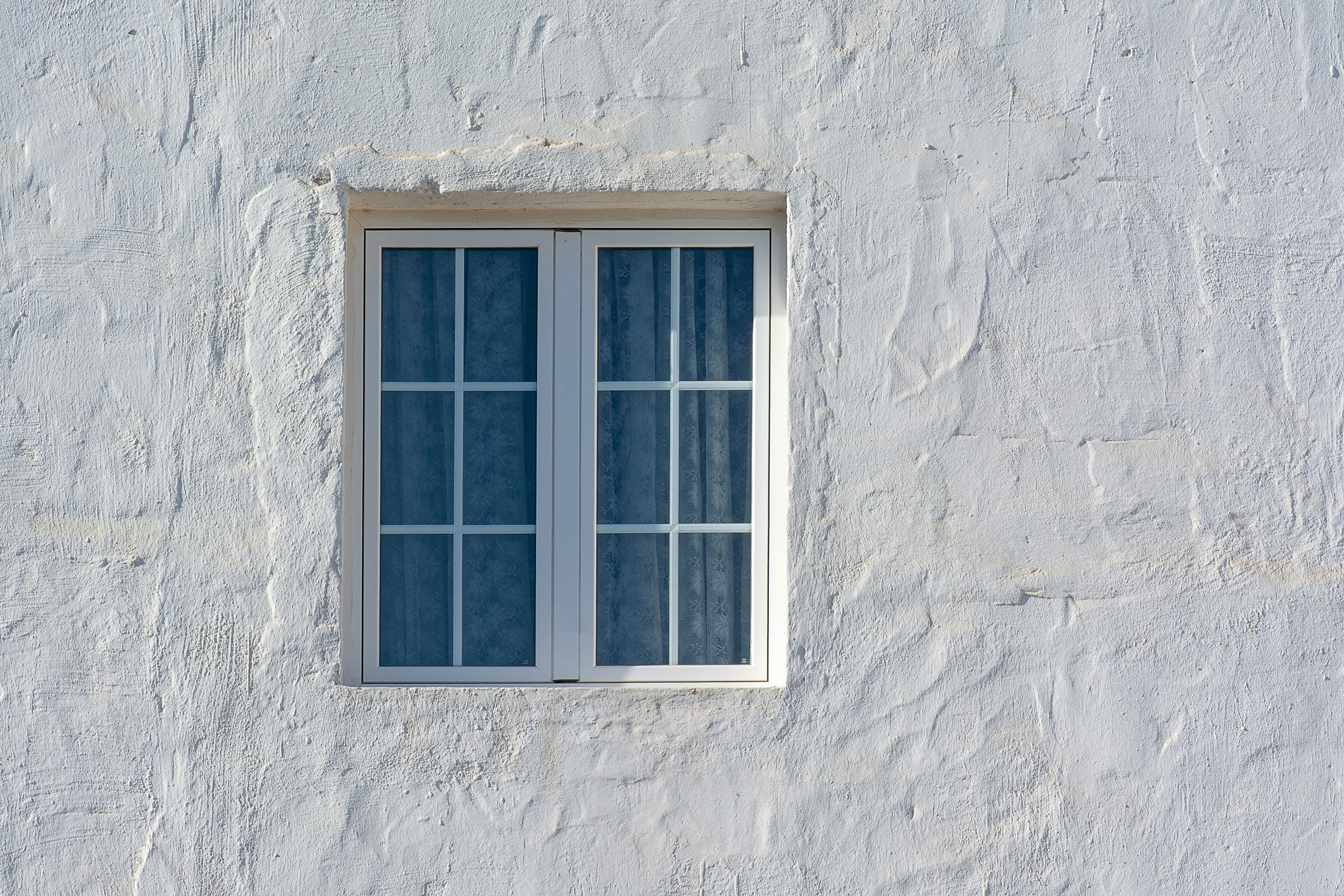 Whitewashed masonry wall with rustic window — the characteristic texture of a limewash paint finish