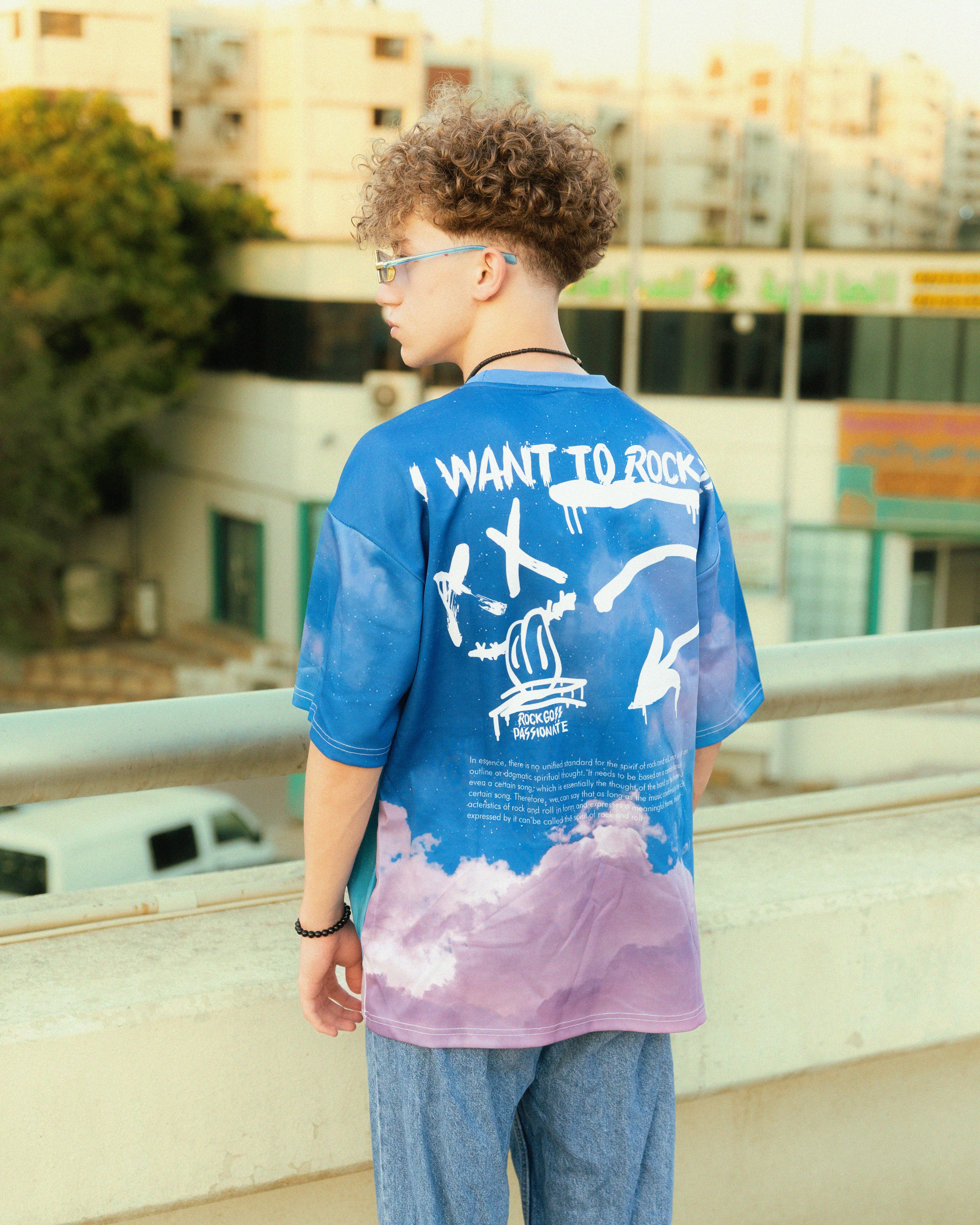 a young man standing on a bridge wearing a t shirt with the words i want to fly