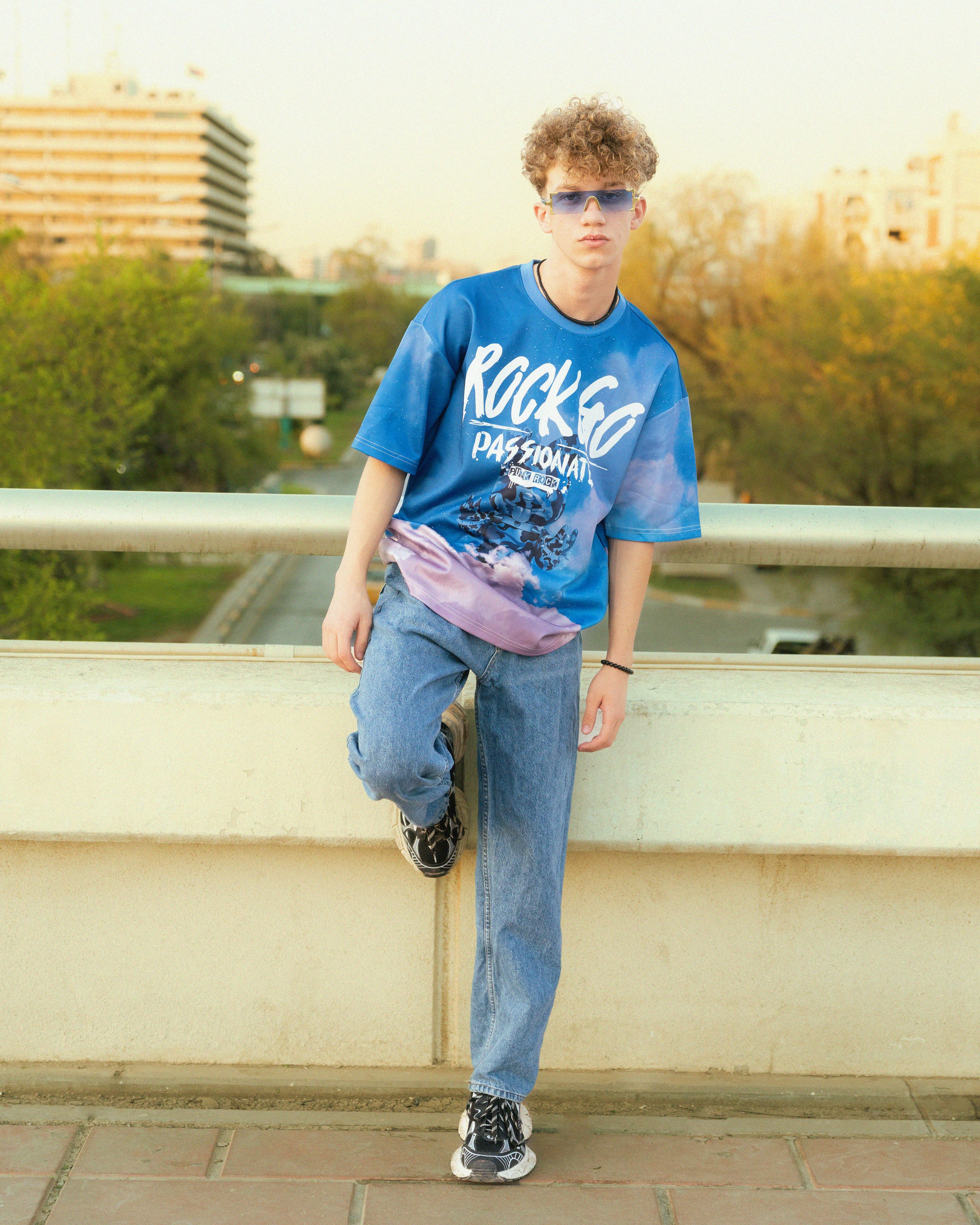 A young man wearing a blue shirt and jeans